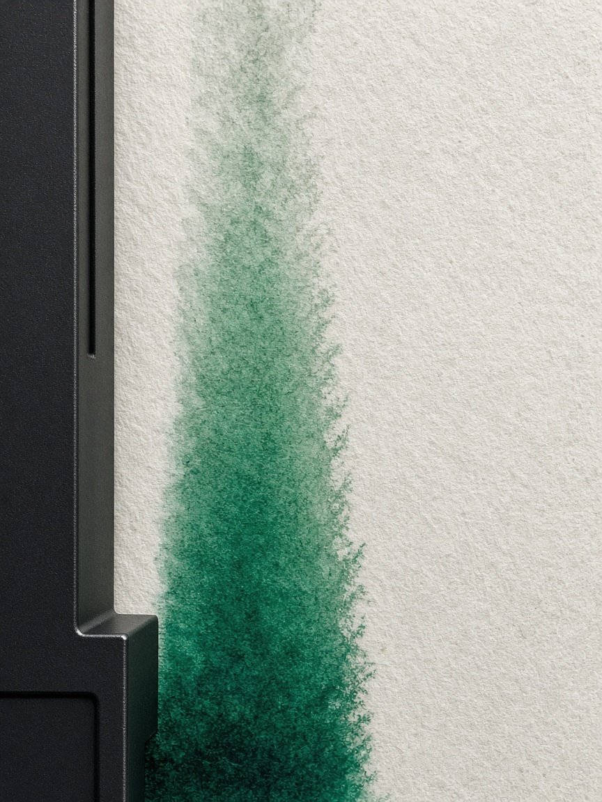 Malachite pigment migrating vertically through cotton paper beside a black anodised housing.